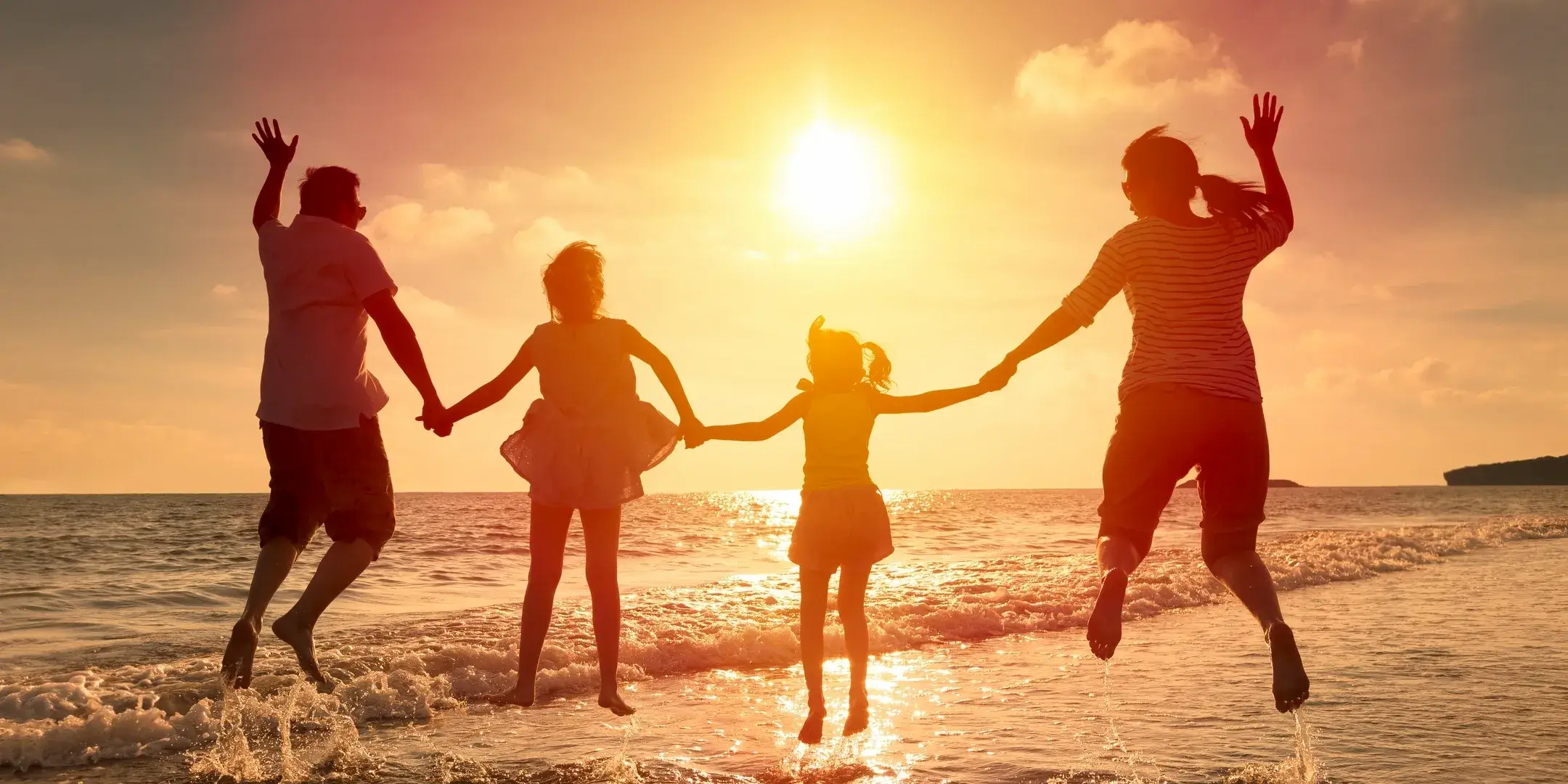 People holding hands together on a beach.