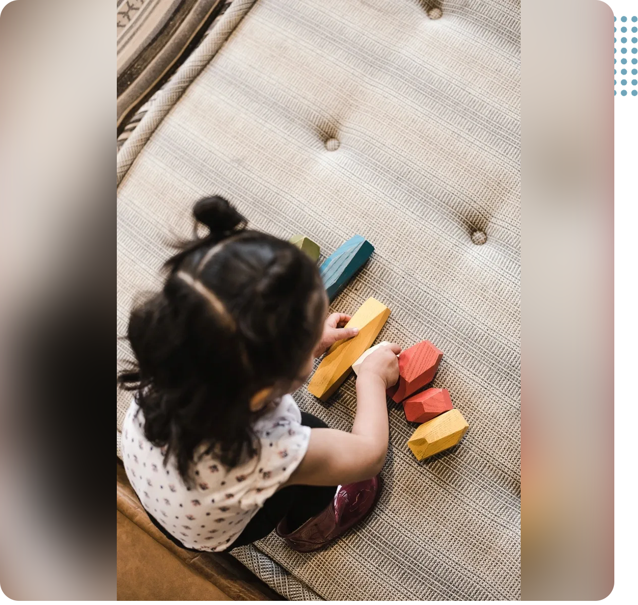 08 A little girl playing with blocks on the floor.